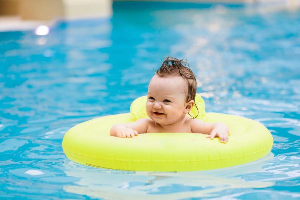 Sweet toddler swimming in a floating ring