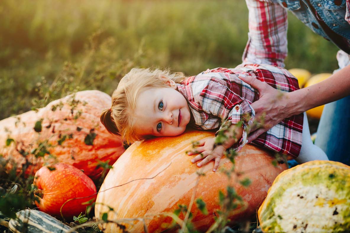 daughter lying on a pumpkin