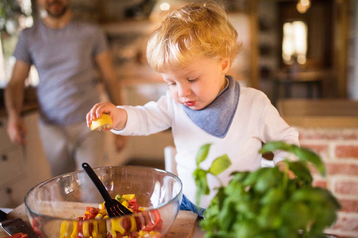Young father with a toddler boy cooking.